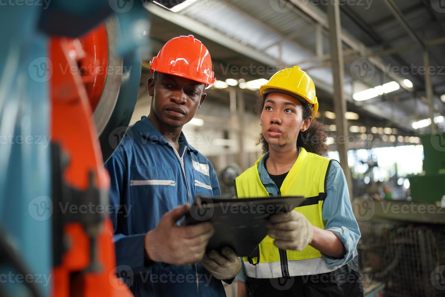 los ingenieros de mantenimiento están trabajando frente a la reparación automatizada de maquinaria cnc en una lista de verificación de mantenimiento en la línea de producción. foto