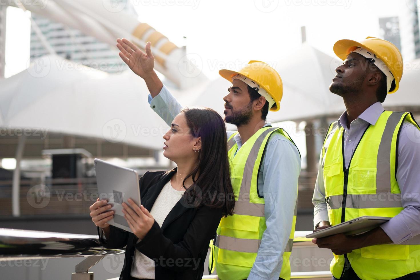 arquitecto, ingeniero civil y trabajador mirando planos y planos, discutiendo problemas en el sitio de construcción foto