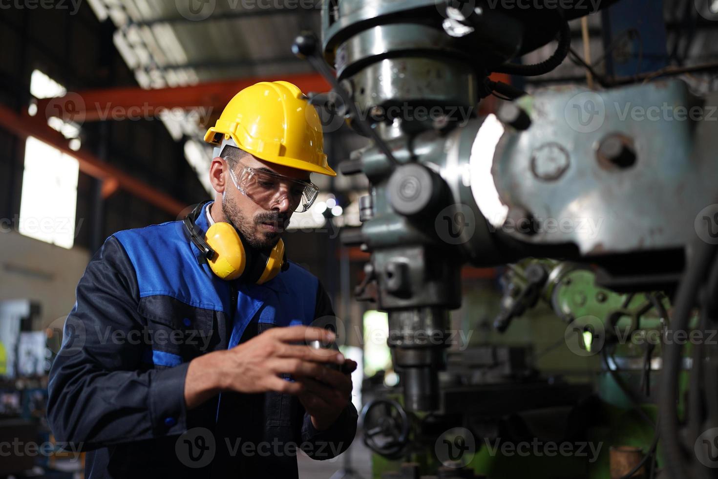 Professional industrial factory employee working with machine part, checking and testing industrial equipment and robot arms in large Electric electronics wire and cable manufacturing plant factory photo