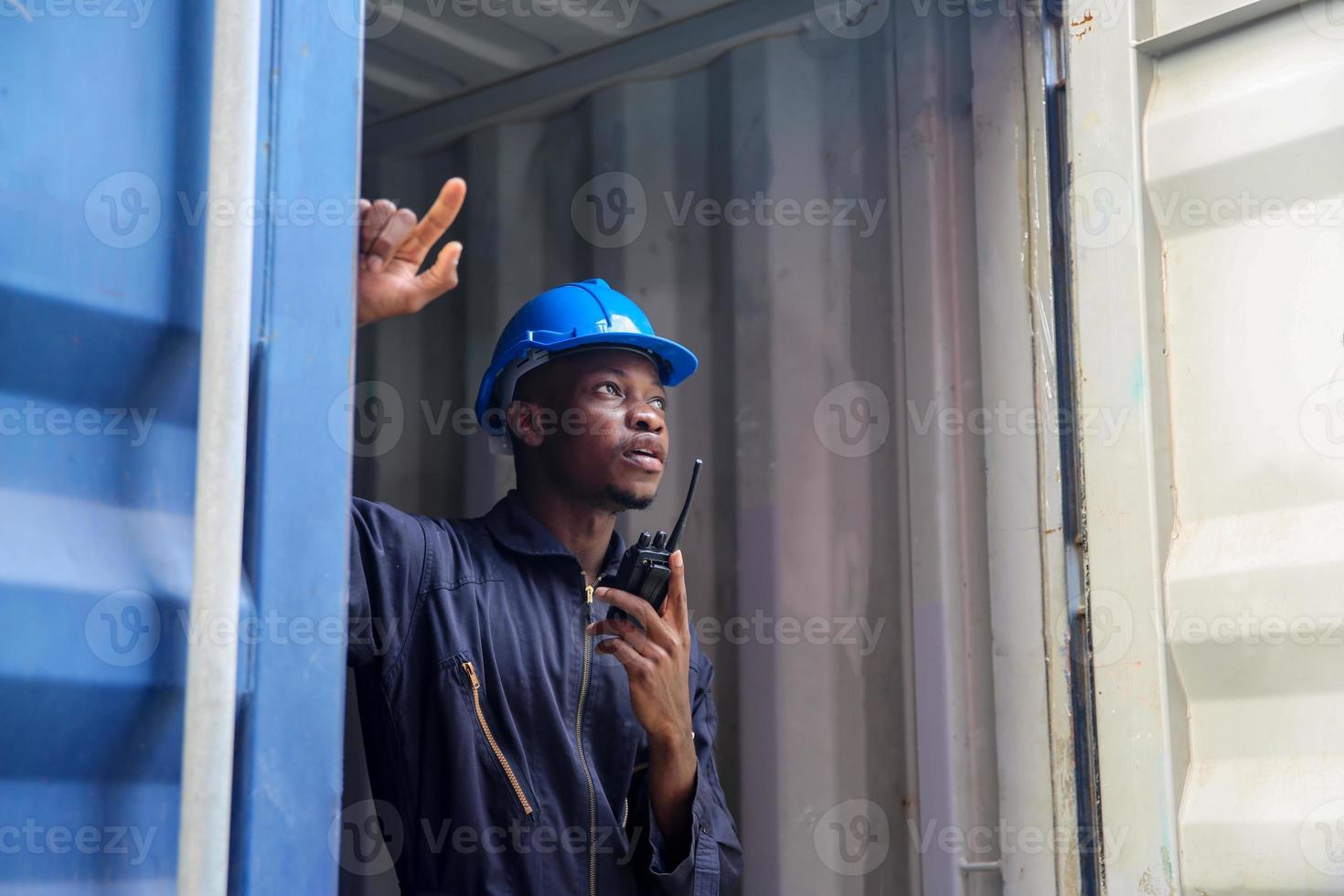 Foreman control loading Containers box from Cargo freight ship for import export. photo
