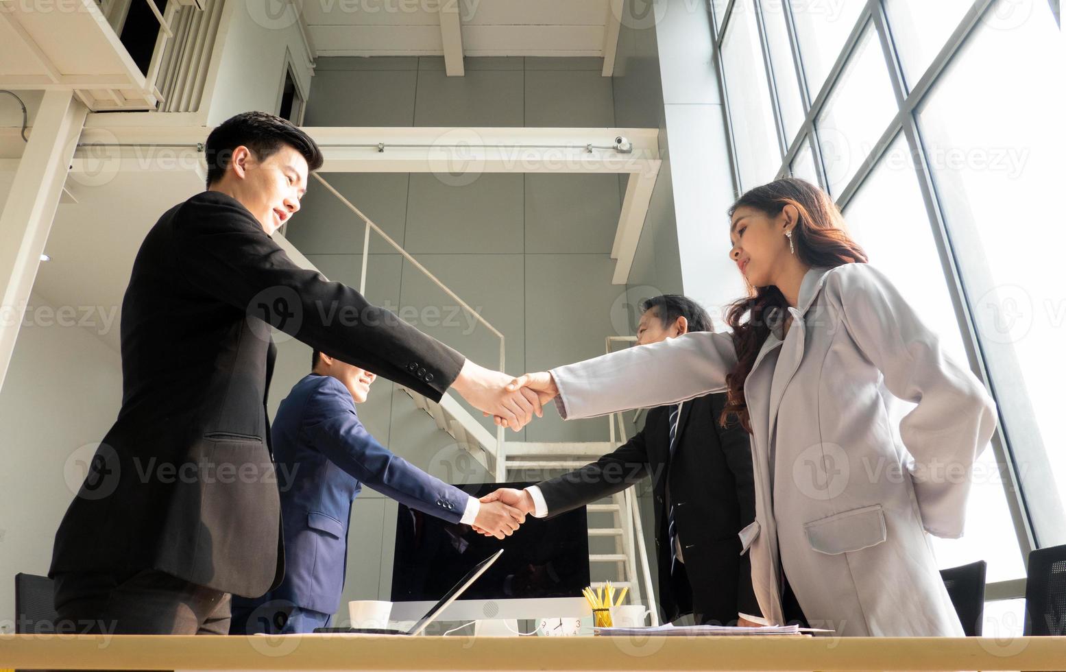 Business people shaking hands in the modern office finishing successful meeting photo