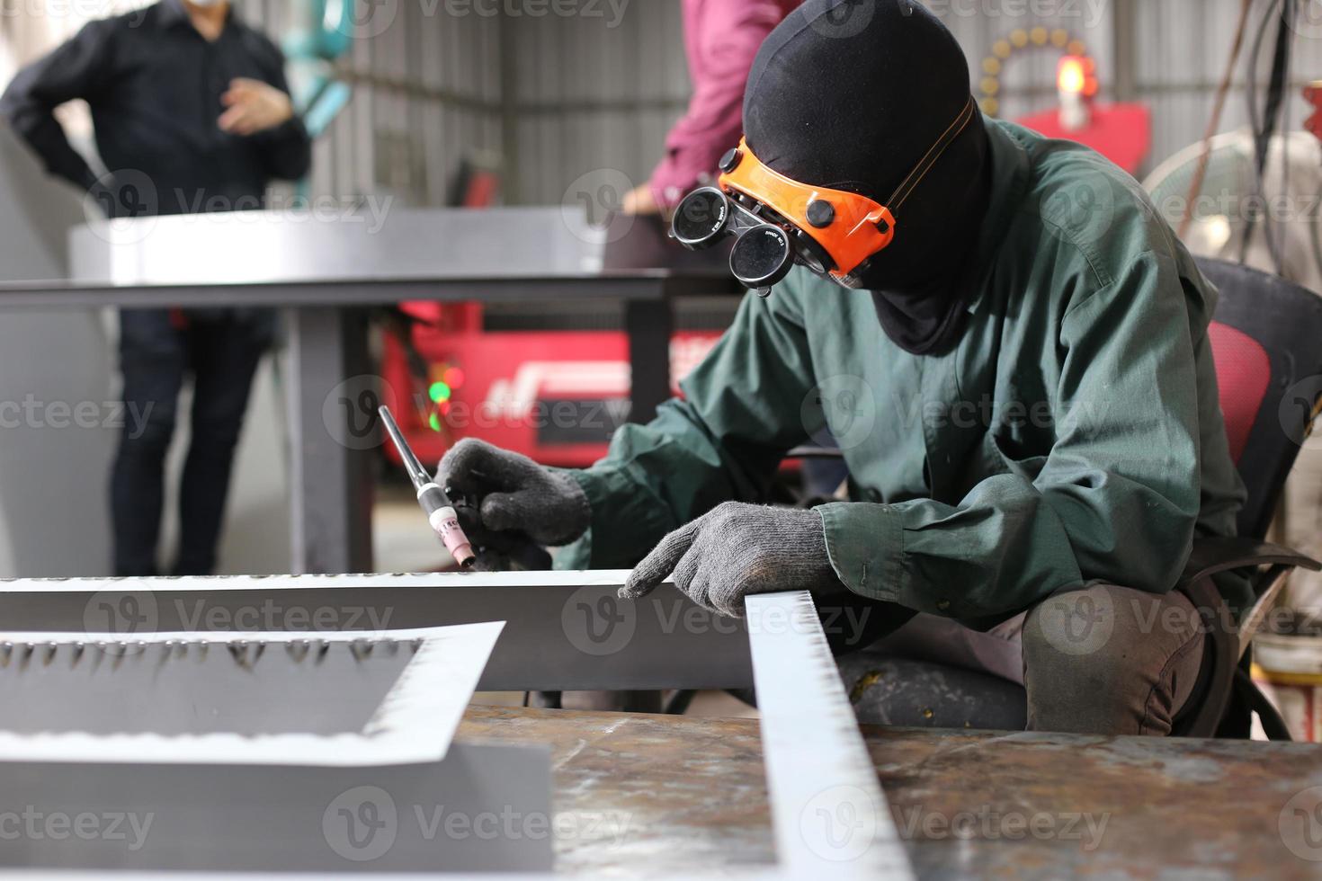 soldador utilizó piedra de moler sobre acero en fábrica con chispas, proceso de soldadura en el taller industrial, manos con instrumento en marco. foto