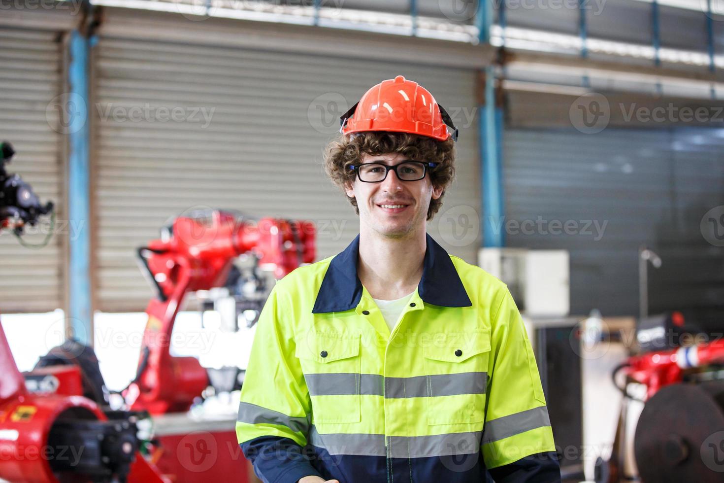 Industrial engineer or worker wearing a helmet while standing in a heavy industrial factory. The Maintenance looking of working at industrial machinery and check security system setup in factory. photo