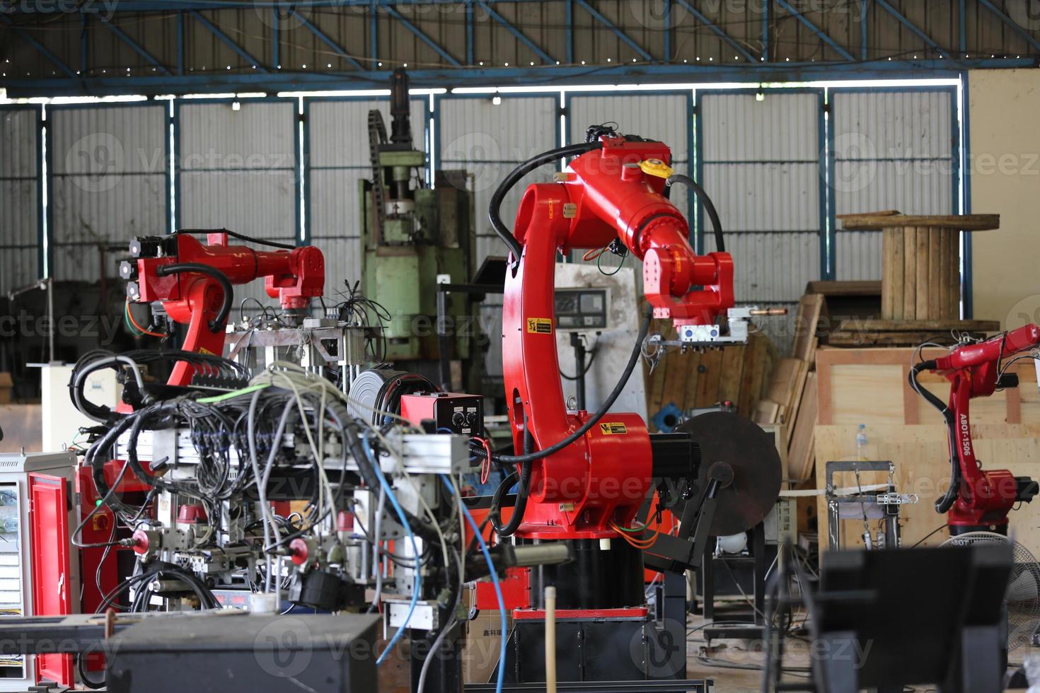 Robotics arm in the metal factory plant . it's performing routine servicing of the welding robotics units equipment. photo
