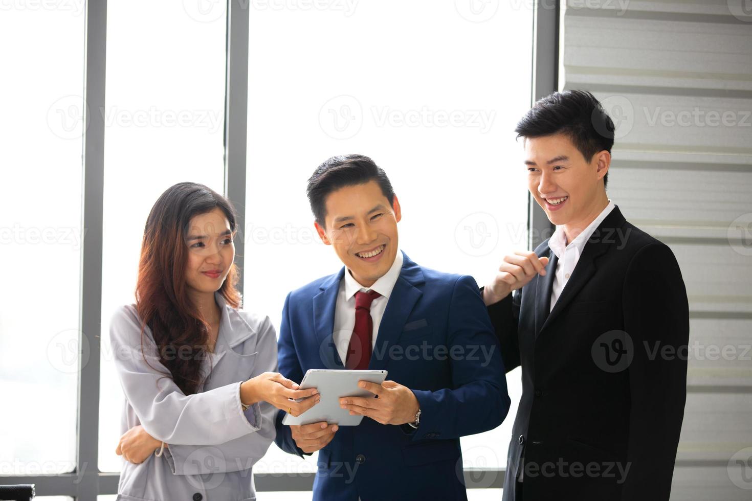 Business professionals. Group of young confident business people analyzing data using computer while spending time in the office photo