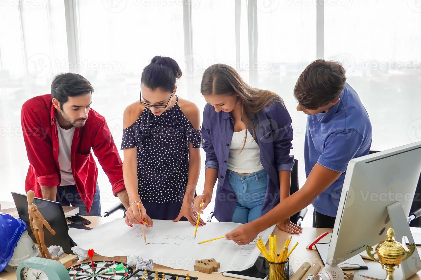 Diverse group of young business people discussing a work project while sitting together at a table in a modern office. coworking concept photo