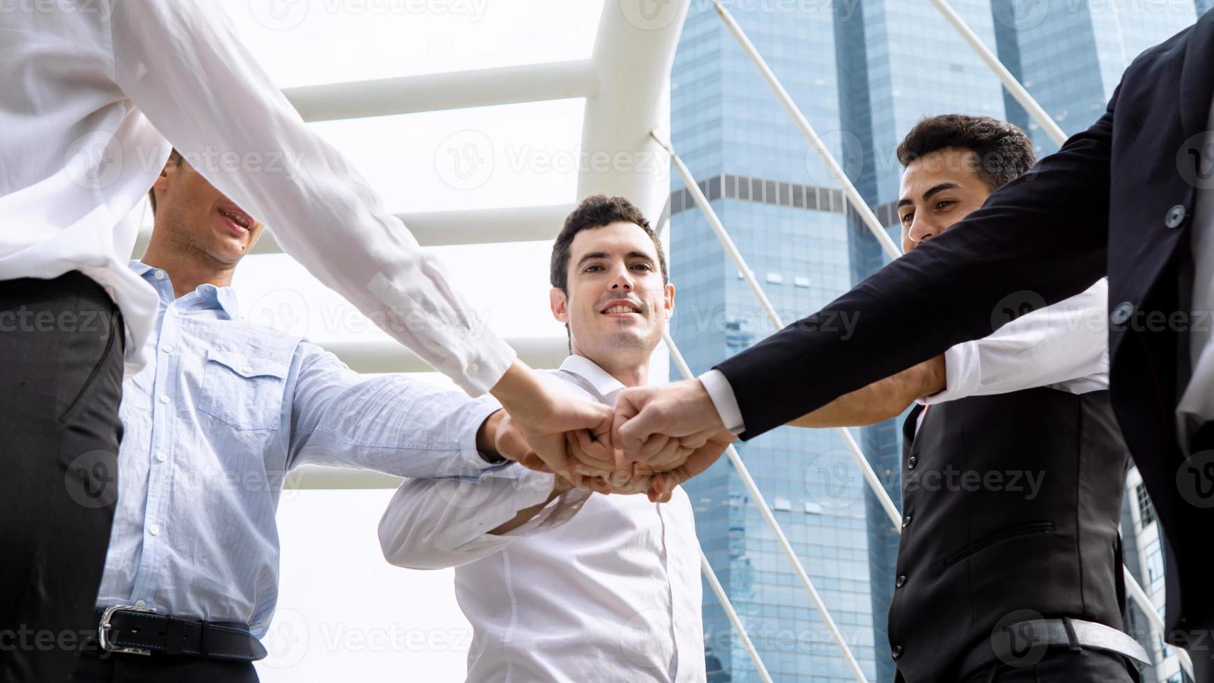 los empresarios exitosos que se unen se ensanchan mostrando una fuerte relación de comunidad de trabajadores. un equipo de hombres de negocios y mujeres de negocios que expresan un sólido trabajo en equipo en la oficina moderna. foto