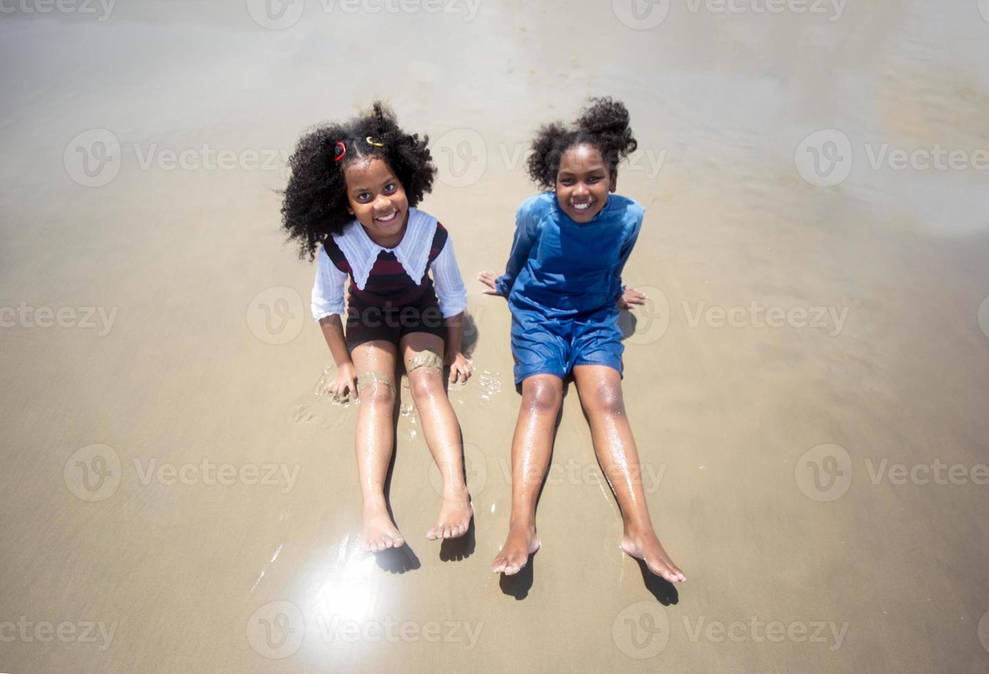 Kids playing running on sand at the beach photo