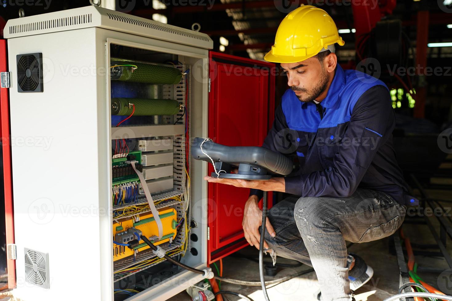 engineer checking control panel and teaching new Automatics robot arm and operating control machine in factory. photo