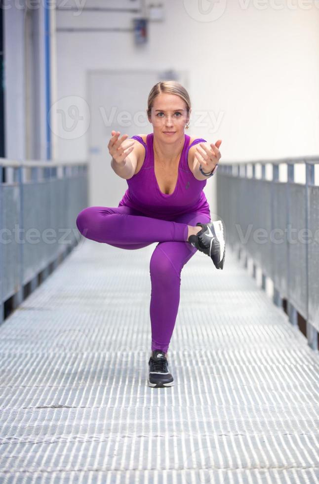 hermosa rubia activa haciendo ejercicio de yoga y entrenamiento al aire libre. foto