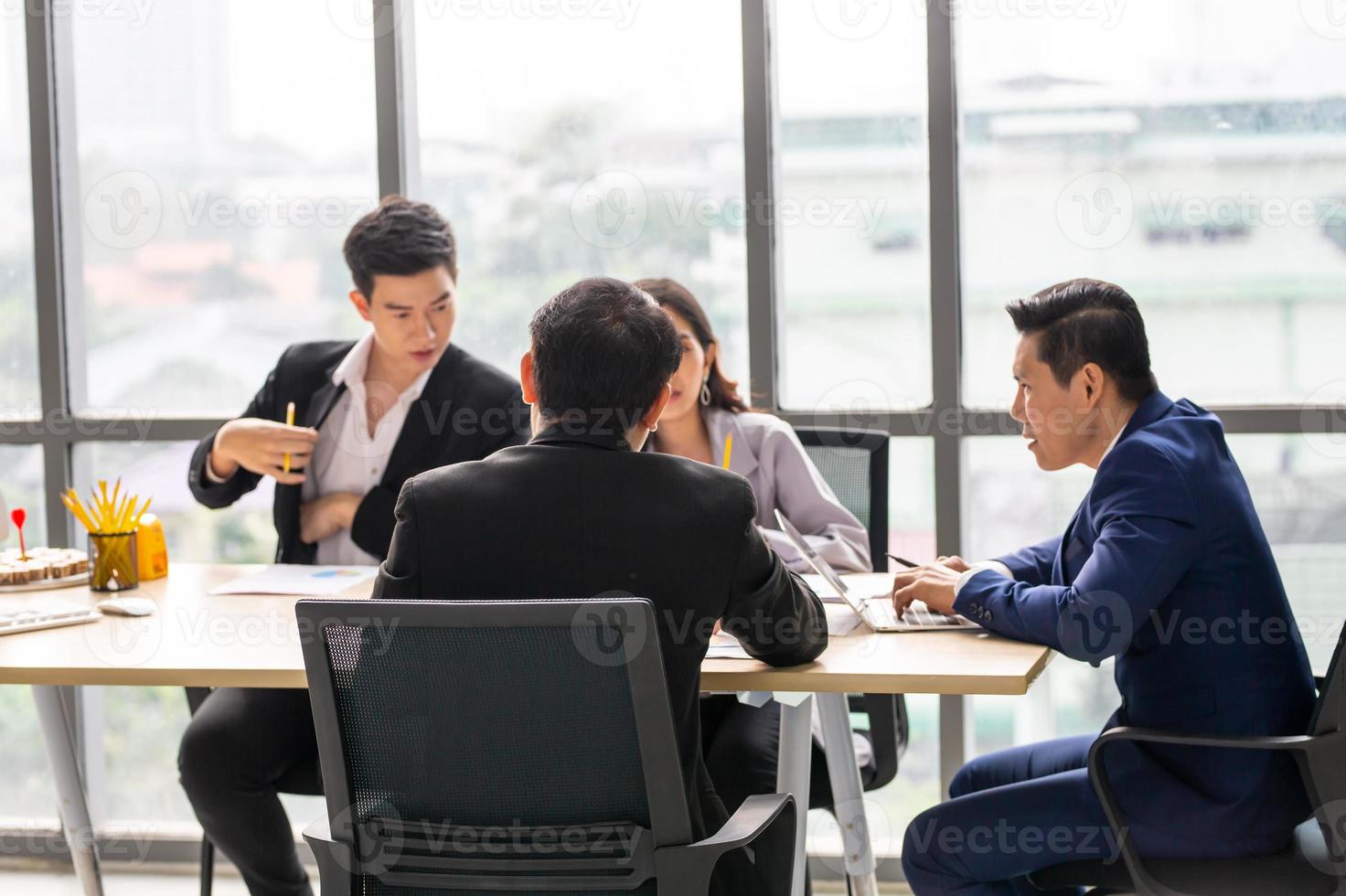 Business professionals. Group of young confident business people analyzing data using computer while spending time in the office photo