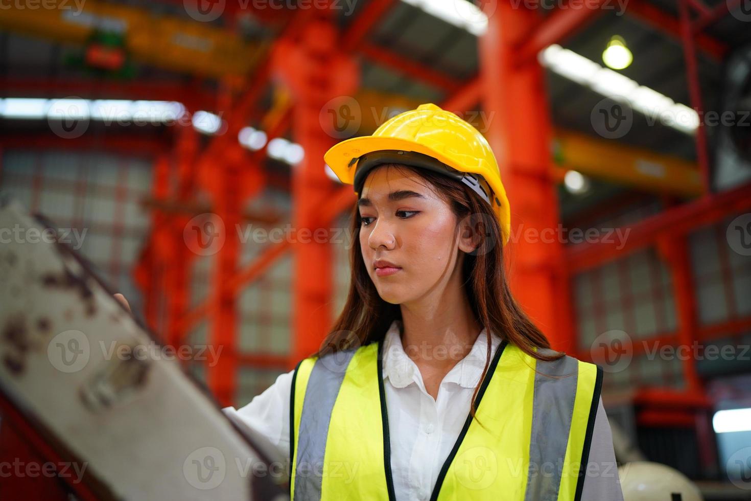 Female worker Foreman or worker work at factory site check up machine or products in site. Engineer or Technician checking Material or Machine on Plant. Industrial and Factory. photo