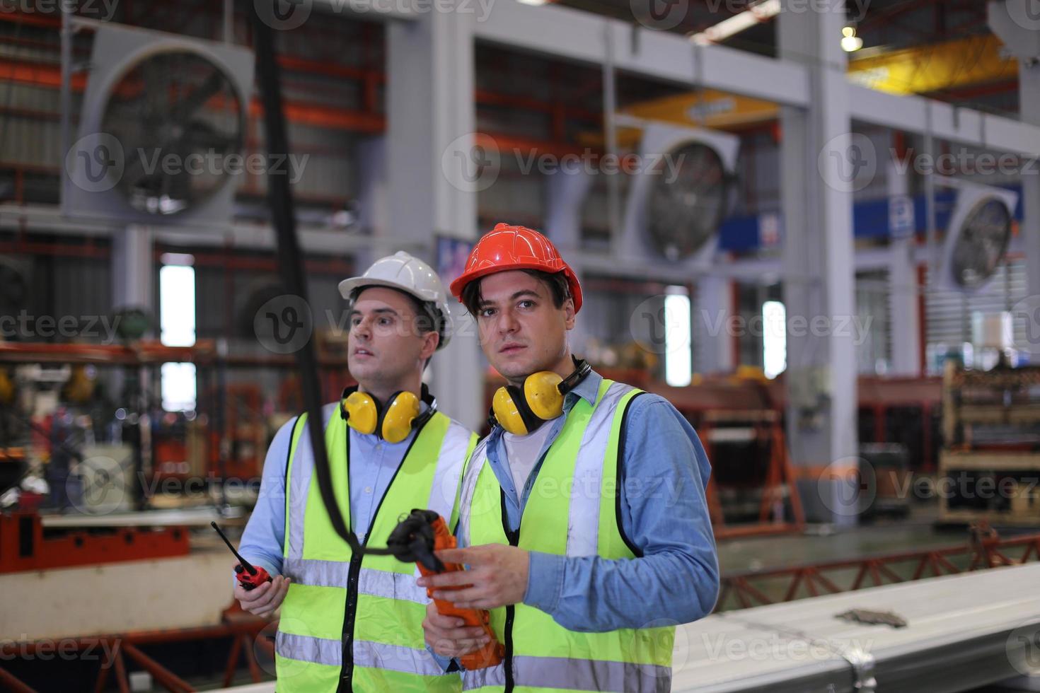 el capataz de los trabajadores de la industria o el trabajo de los trabajadores en el sitio de la fábrica revisan la máquina o los productos en el sitio. ingeniero o técnico revisando material o máquina en planta. industrial y fábrica. foto