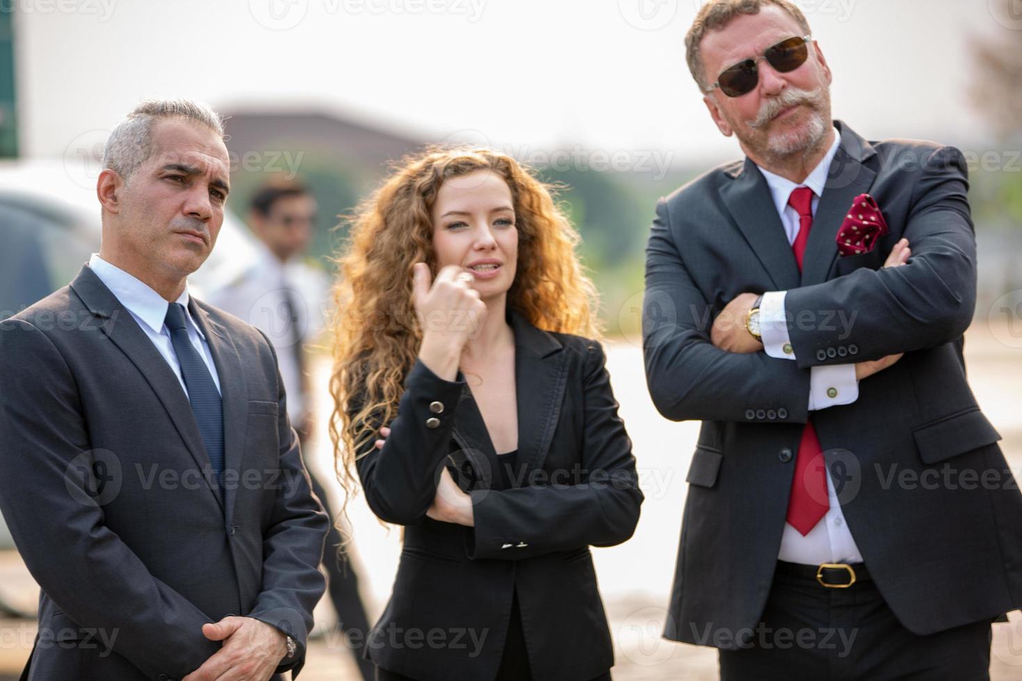 Successful business people standing together widen out showing strong relationship of worker community. A team of businessman and businesswoman expressing a strong group teamwork at the modern office. photo