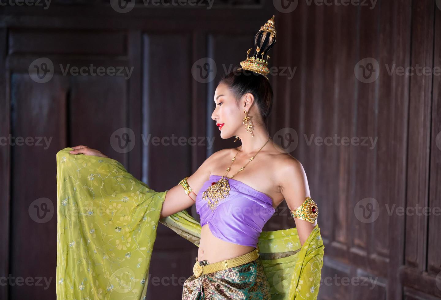 Young Asian women in Traditional dress in the boat and pink lotus flowers in the pond.Beautiful girls in traditional costume.Thai girl in retro Thai dress, Thai girl in traditional dress costume photo