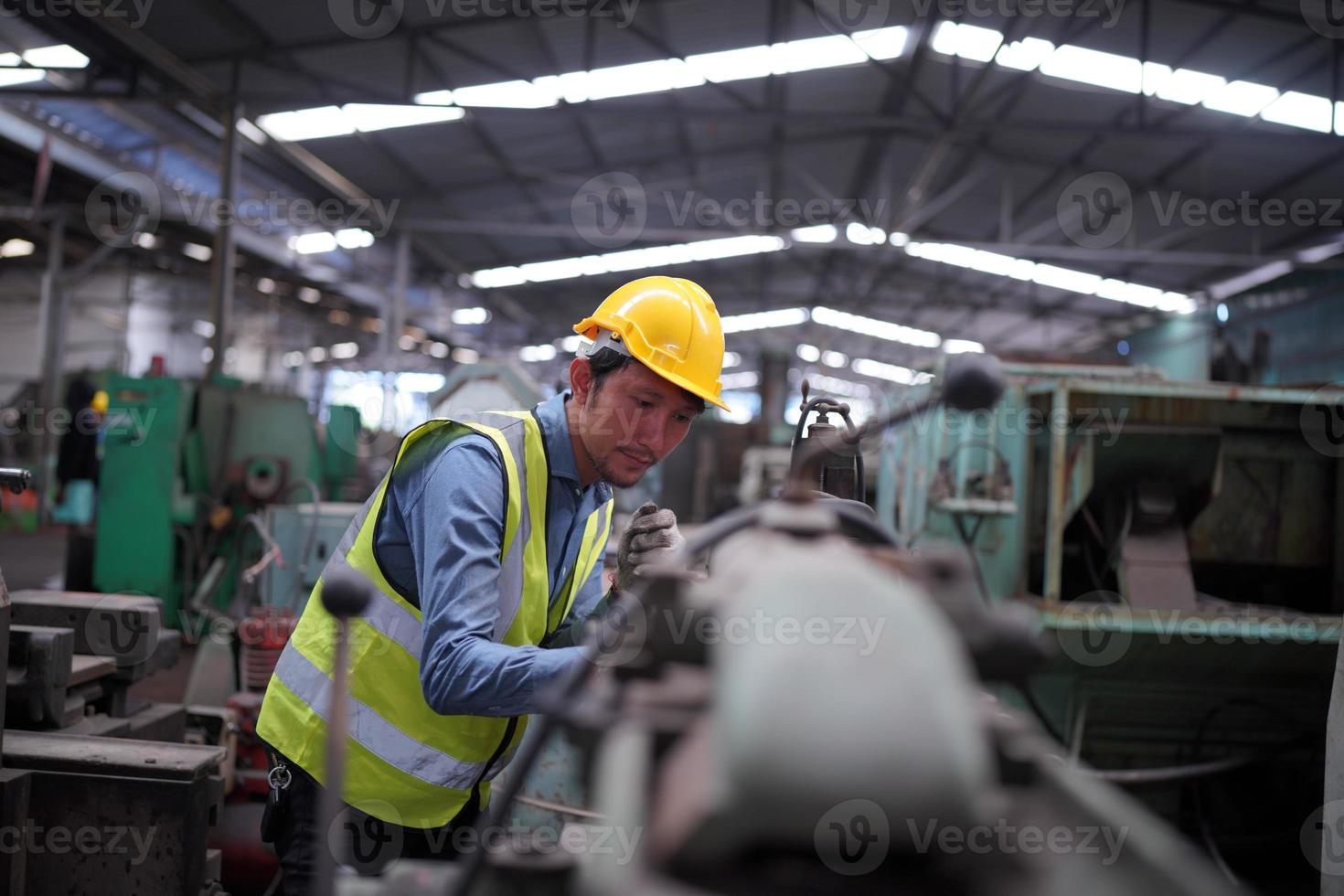 Maintenance Engineers is working in front of the automated CNC machinery repair on a maintenance checklist at the production line. photo