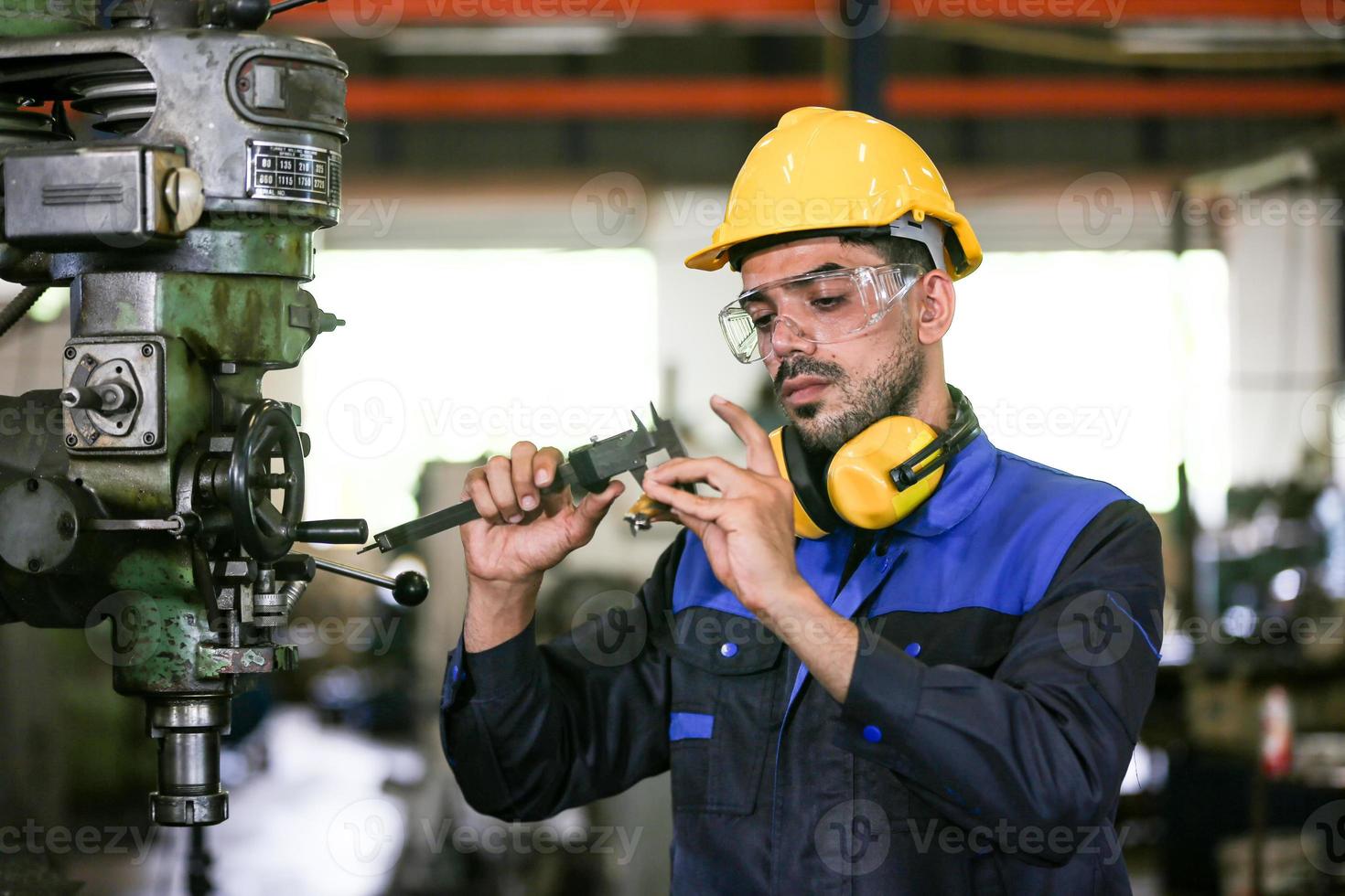 Professional industrial factory employee working with machine part, checking and testing industrial equipment and robot arms in large Electric electronics wire and cable manufacturing plant factory photo