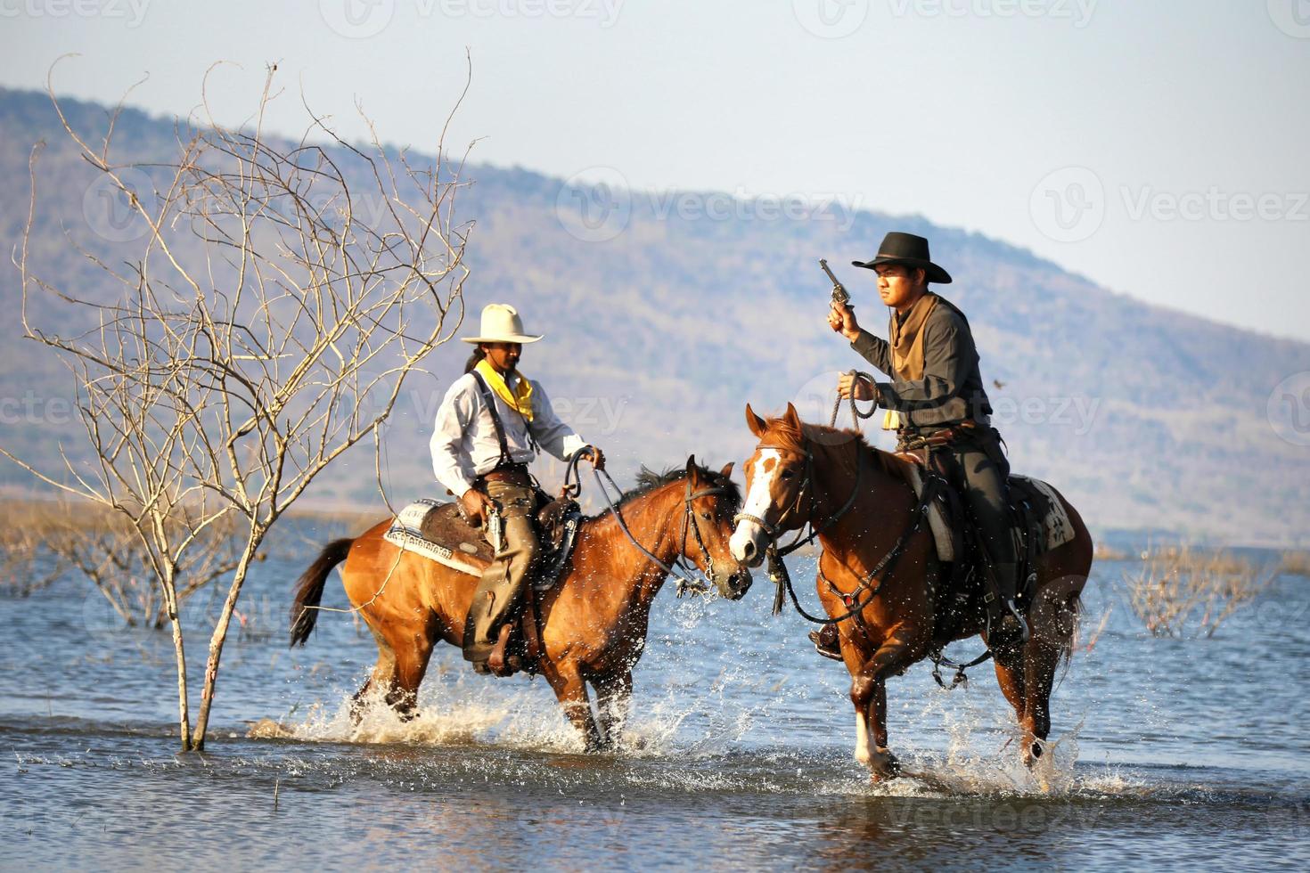 Cowboy on horseback against a beautiful sunset, cowboy and horse at first light, mountain, river and lifestyle with natural light background photo