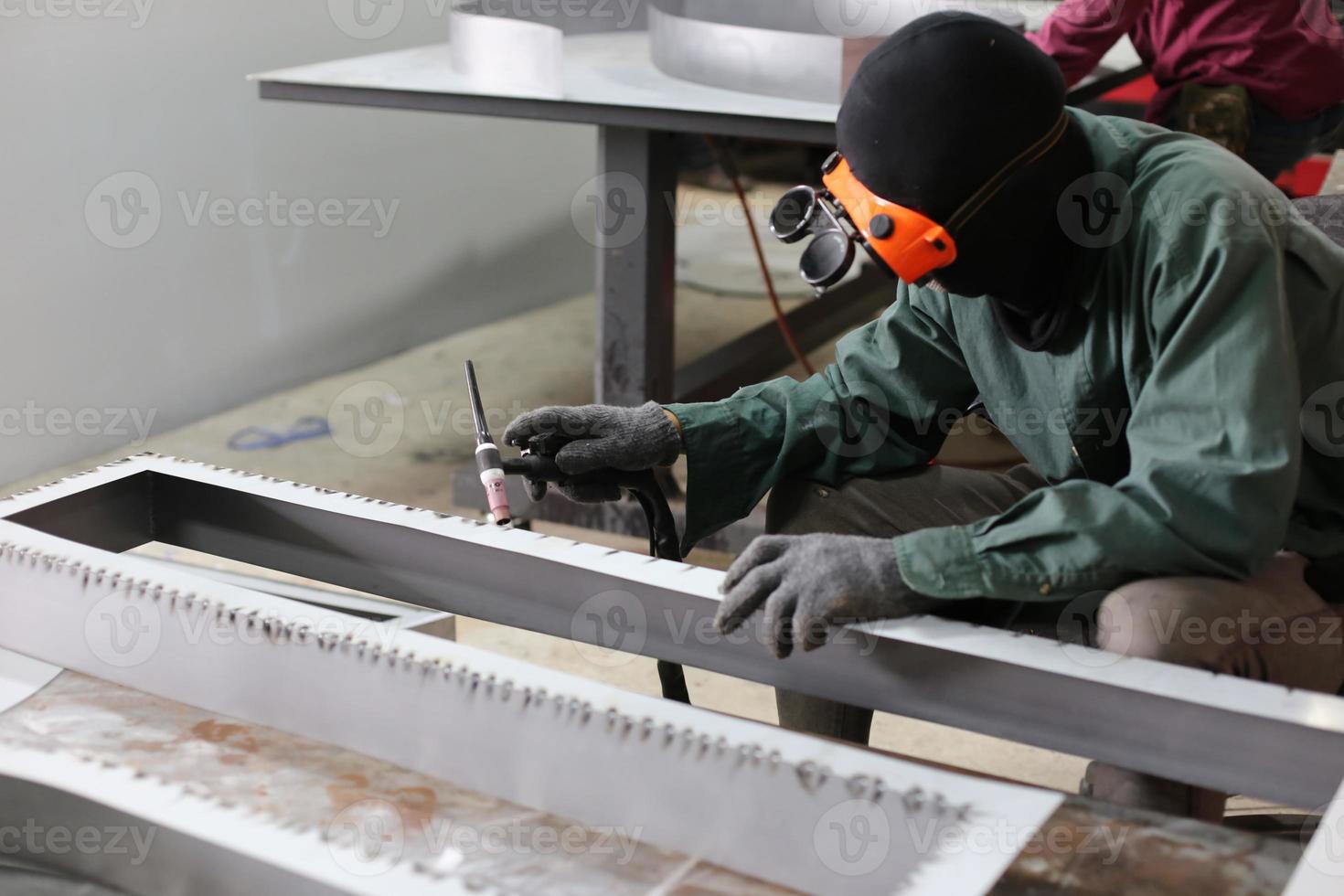 soldador utilizó piedra de moler sobre acero en fábrica con chispas, proceso de soldadura en el taller industrial, manos con instrumento en marco. foto