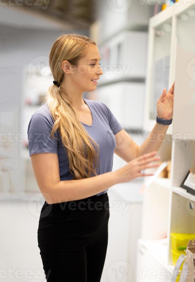 side view of women looking for something on bookshelf photo