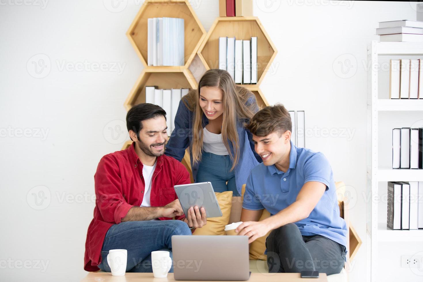 Diverse group of young business people discussing a work project while sitting together at a table in a modern office. coworking concept photo