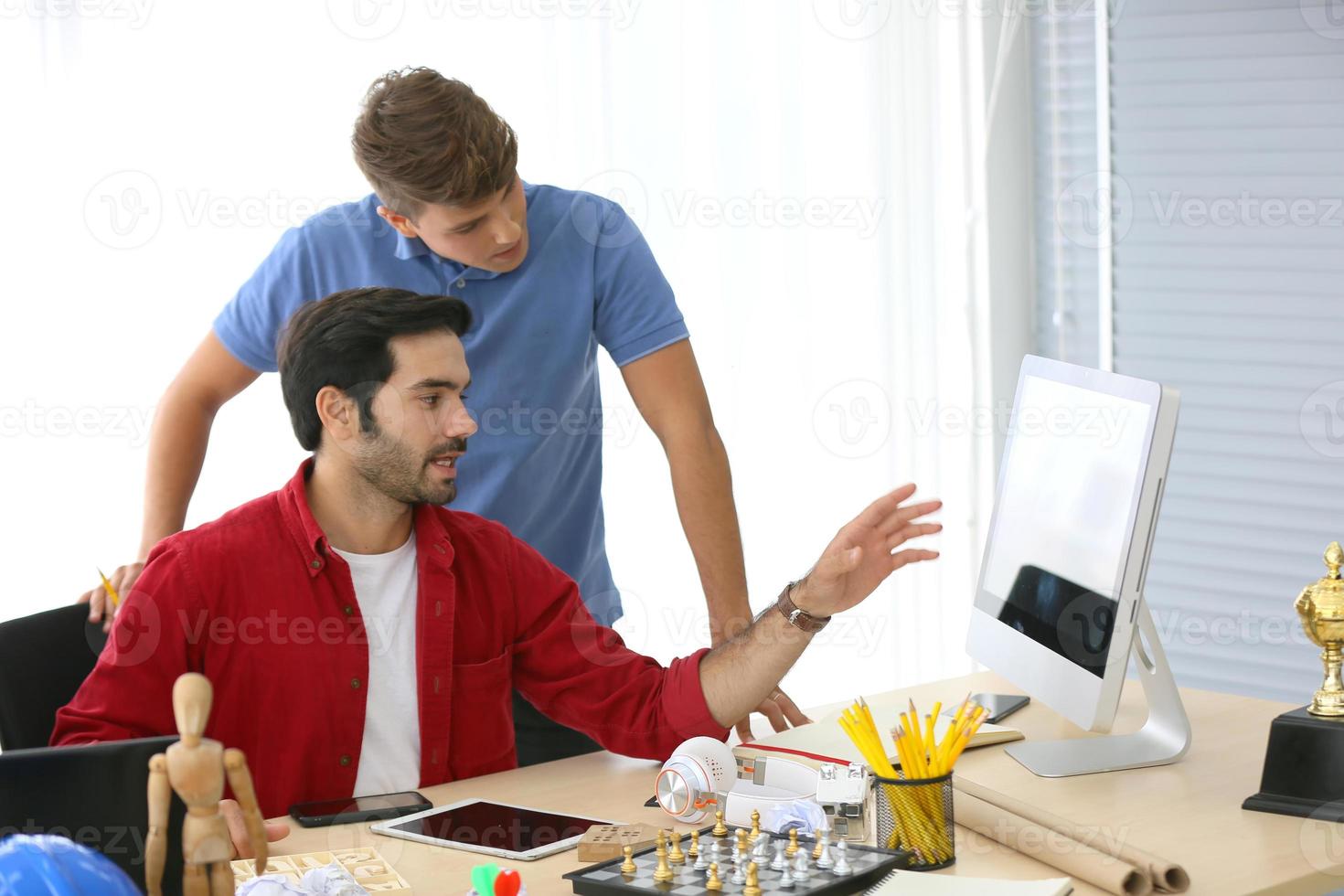 grupo diverso de jóvenes empresarios discutiendo un proyecto de trabajo mientras se sientan juntos en una mesa en una oficina moderna. concepto de coworking foto