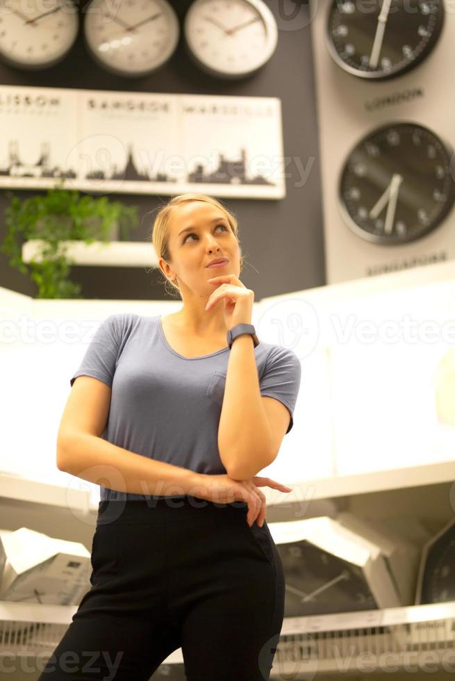 portrait of women looking away while standing against clocks on wall photo