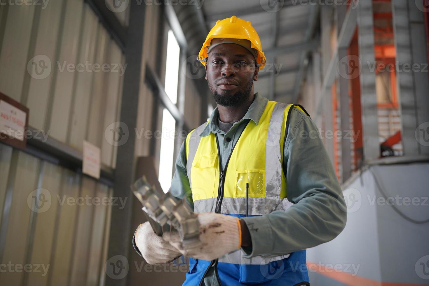 Men industrial engineer wearing a safety helmet while standing in a heavy industrial factory. The Maintenance looking of working at industrial machinery and check security system setup in factory. photo