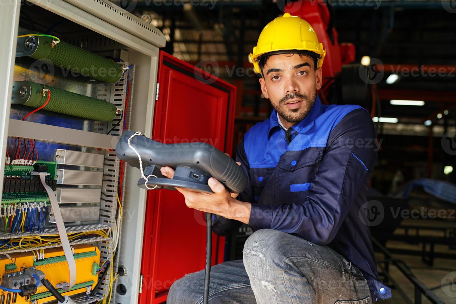 engineer checking control panel and teaching new Automatics robot arm and operating control machine in factory. photo