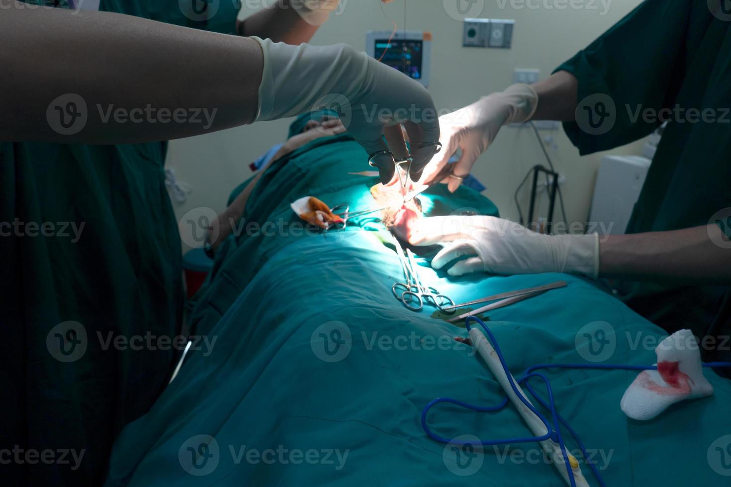 Midsection of surgery team operating Medical Team Performing Surgical Operation in Modern Operating Room or Group of surgeons in operating room with surgery equipment. photo