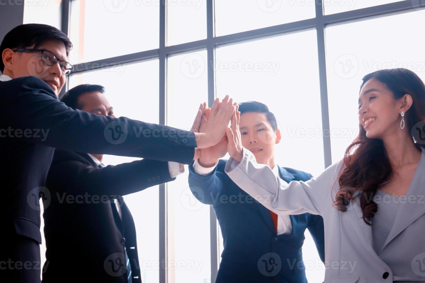 Successful business people standing together widen out showing strong relationship of worker community. A team of businessman and businesswoman expressing a strong group teamwork at the modern office. photo