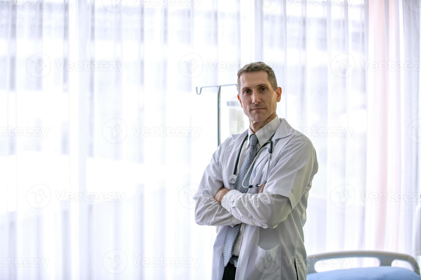 doctor con los brazos cruzados sosteniendo estetoscopio foto