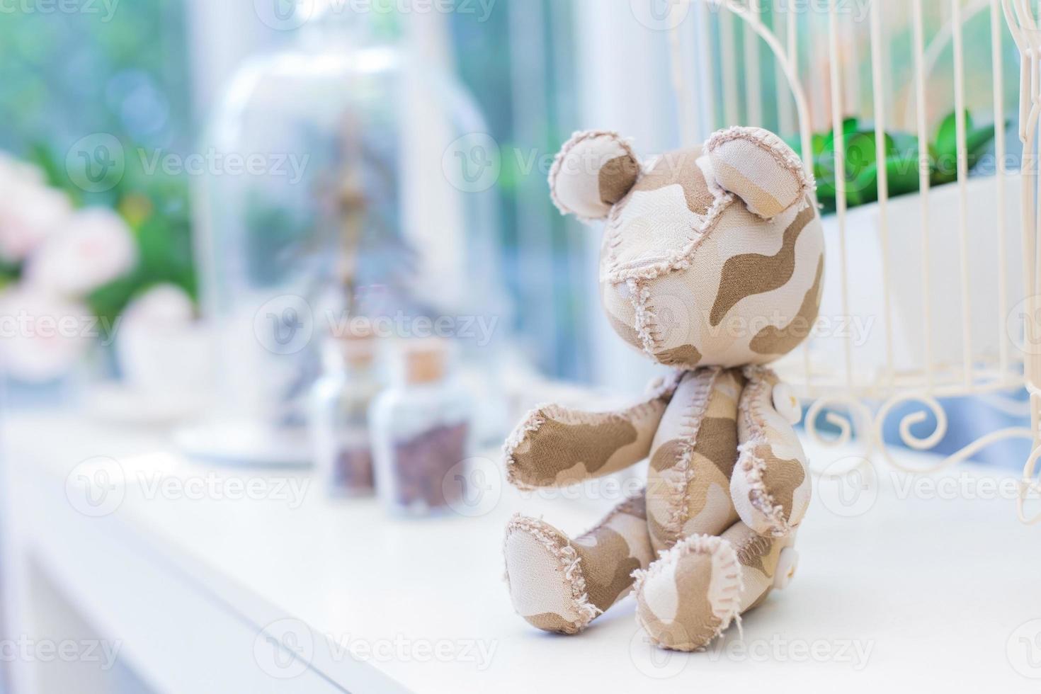 Teddy bear is a fabric bear doll which it put on a white table near window as a copy space background. photo