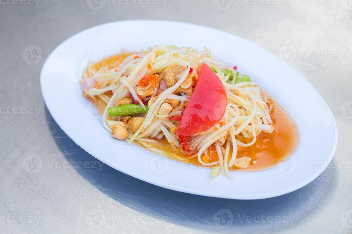 Papaya salad is a spicy salad made from shredded unripe papaya. Originating from ethnic Lao people, it is also eaten throughout Southeast Asia. It is Thai style food. photo