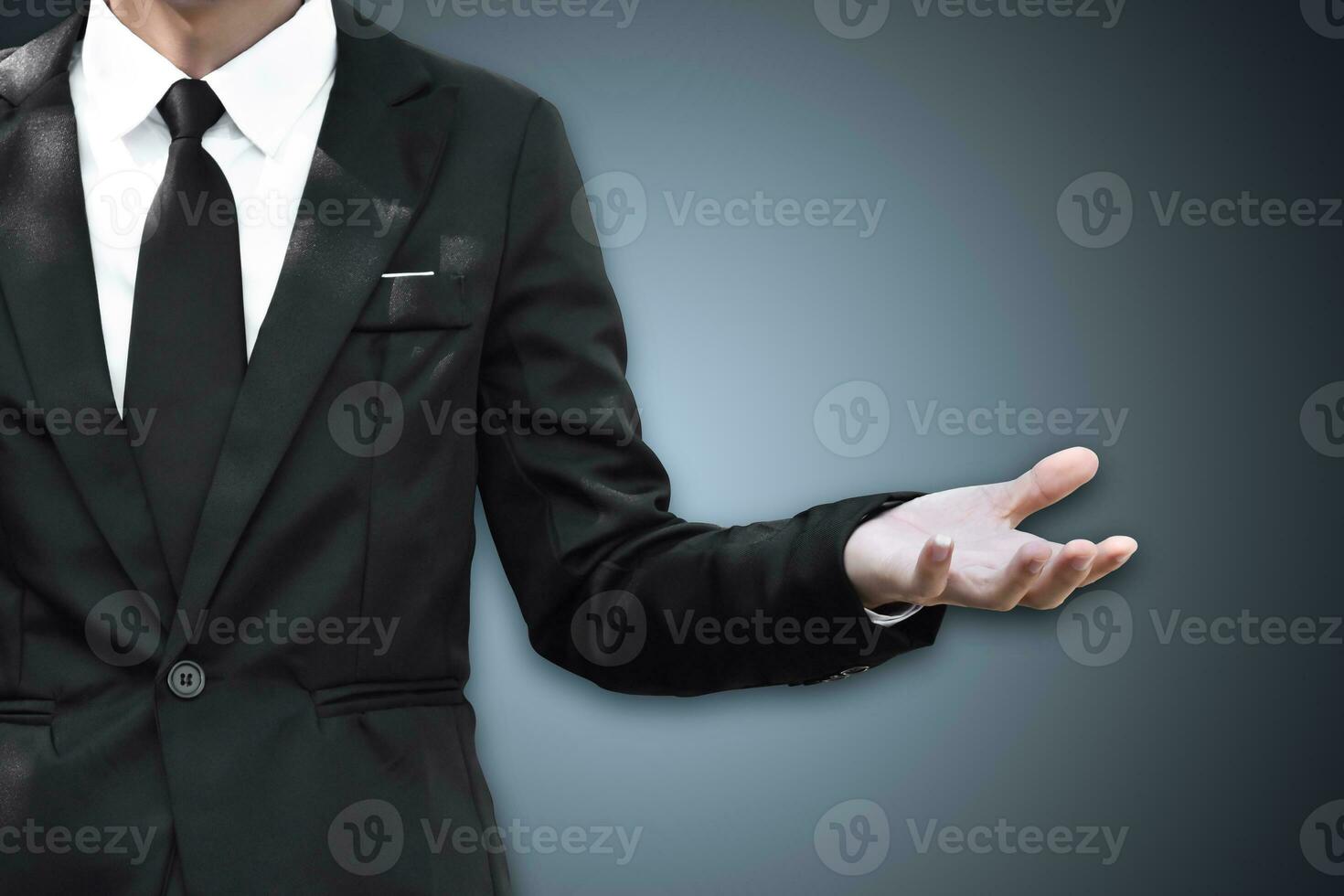 hombre de negocios de pie y muestra la mano extendida con la palma abierta, copie el espacio. foto