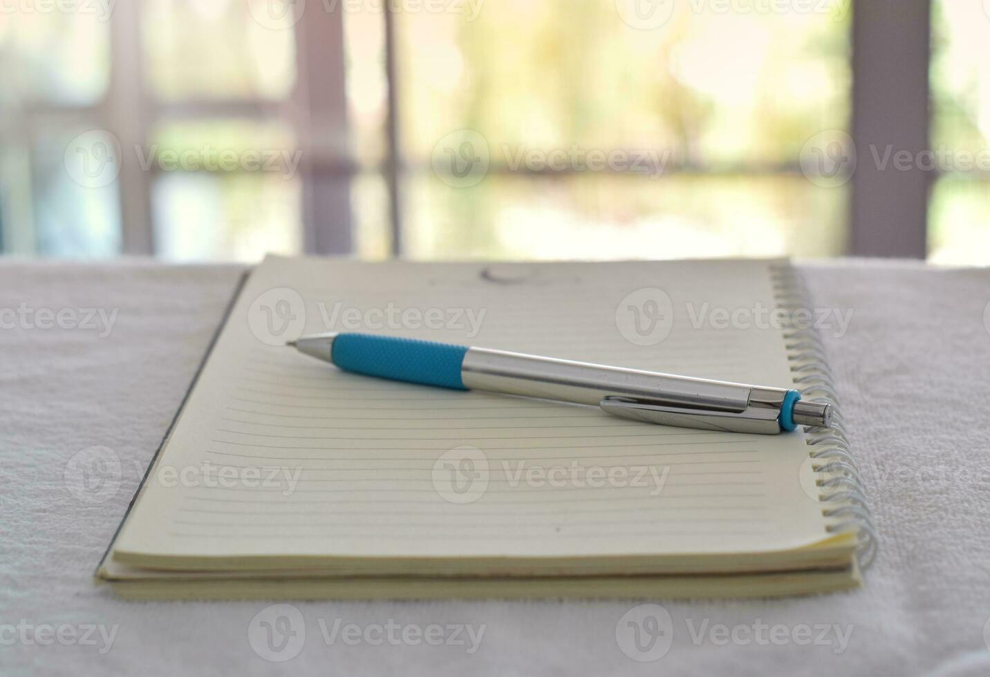 Close up of pen in notebook on office desk with blurry background. photo