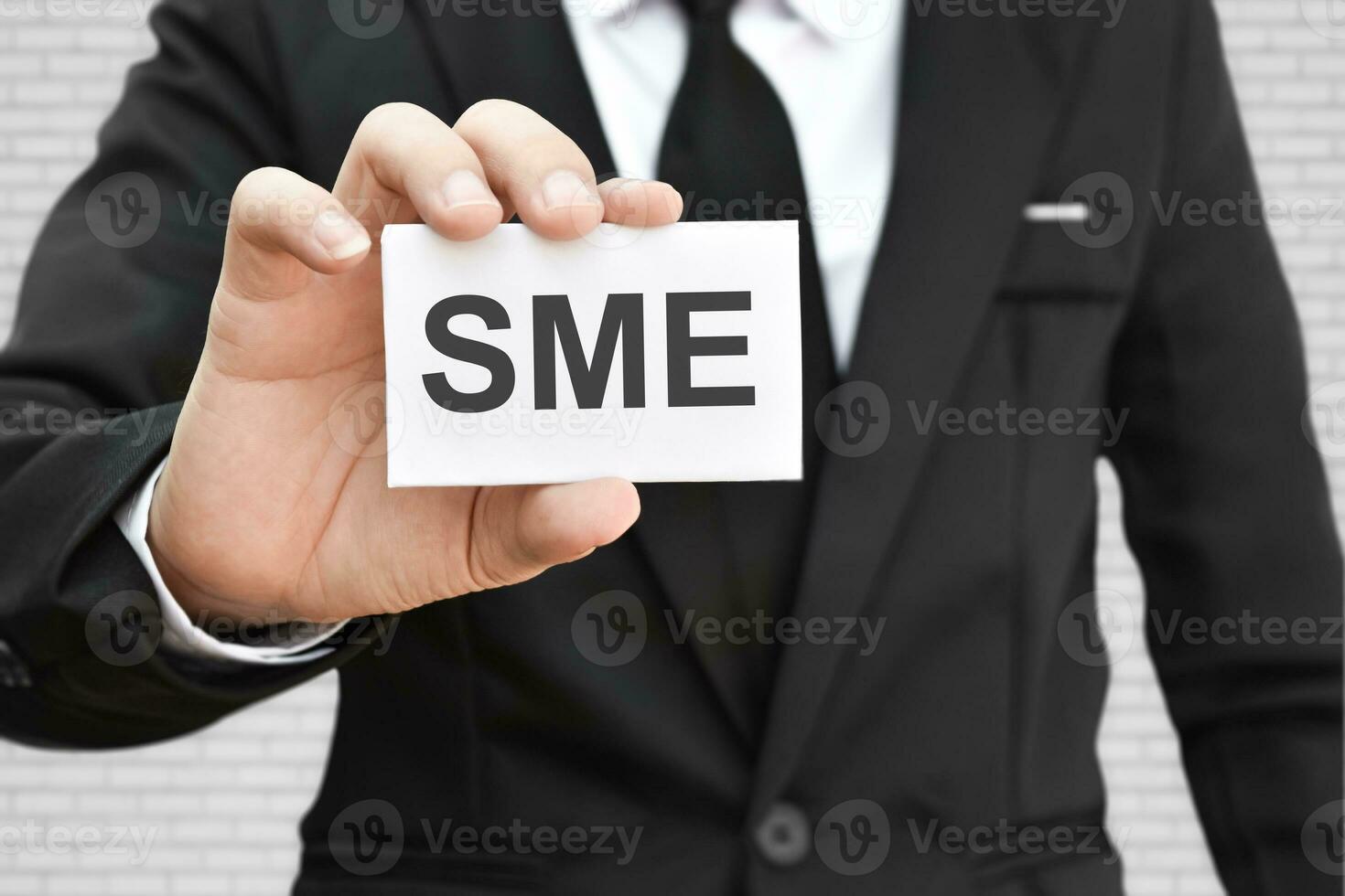 Man hand holding paper card with word SME. Concept of small and medium-sized enterprises business. photo