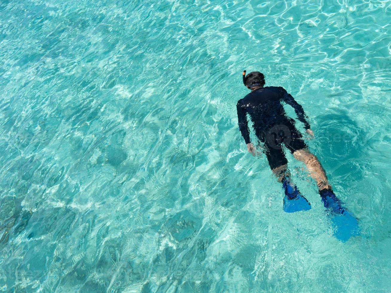 Young woman snorkeling in tropical water photo