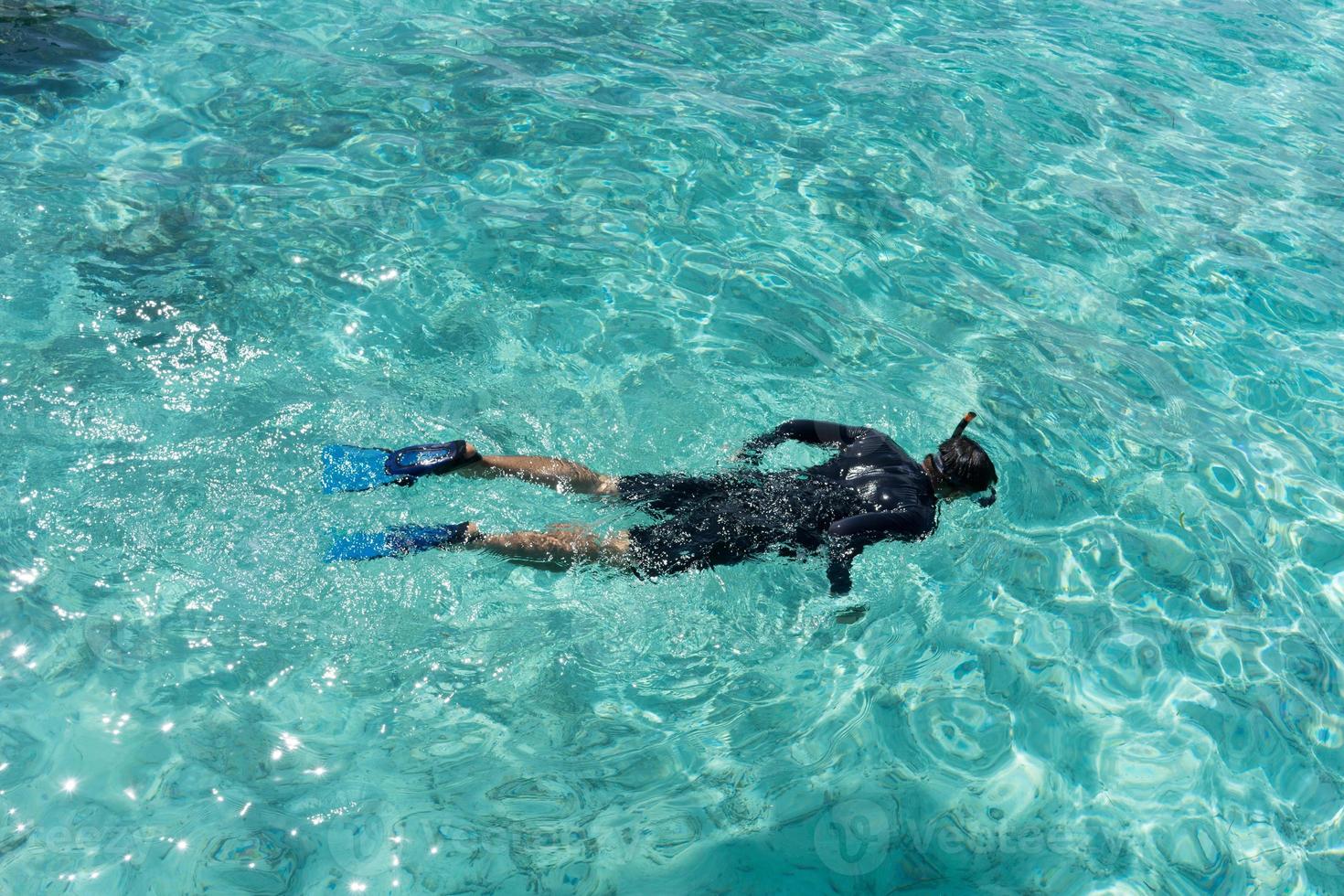 mujer joven buceando en aguas tropicales foto