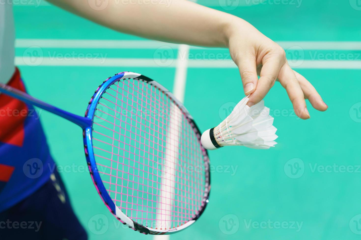 woman holding a badminton racket ready to hit shuttecock photo