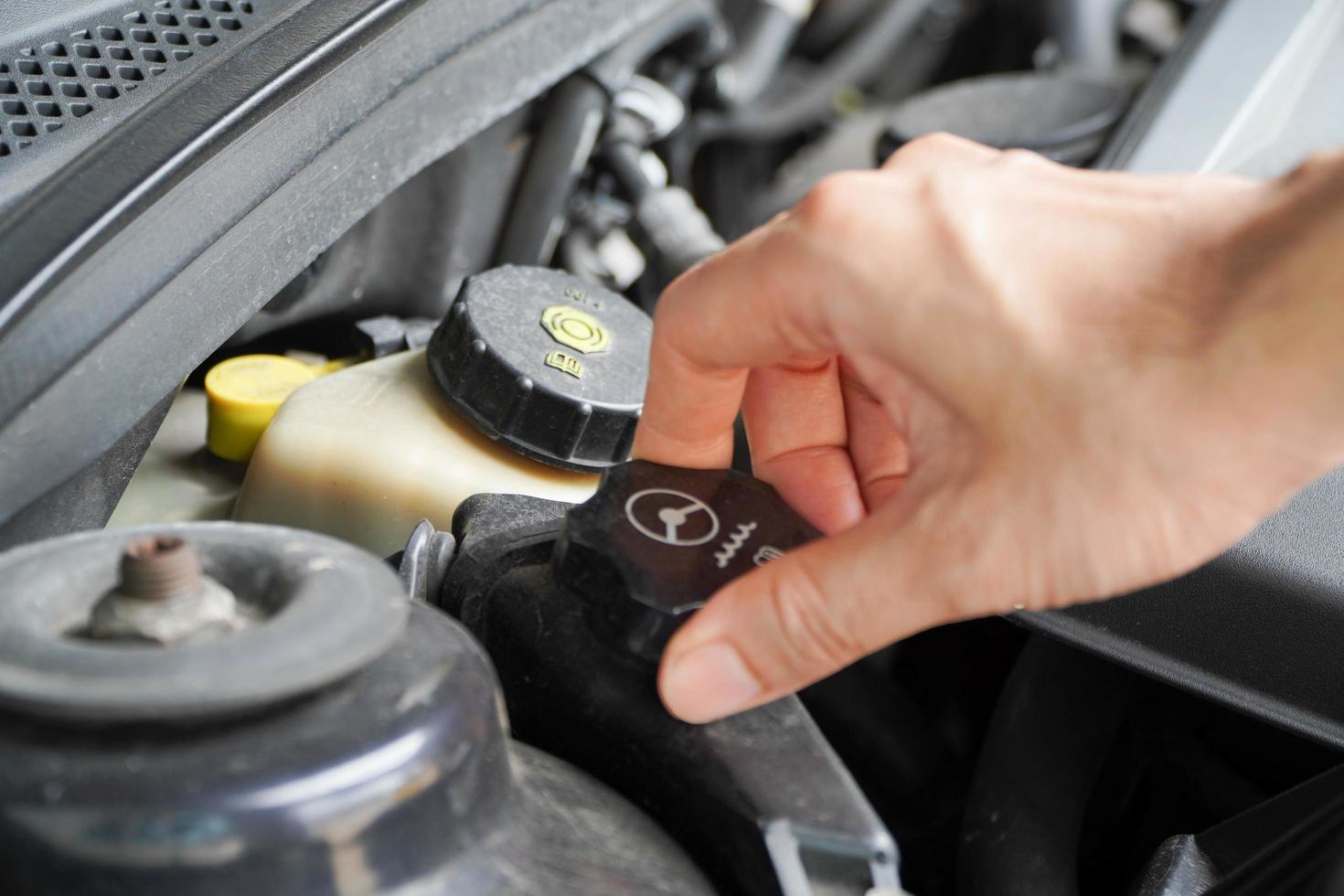 Asian technicians inspect car power steering oil for engine compartment care and basic service concept of the vehicle and braking system. photo