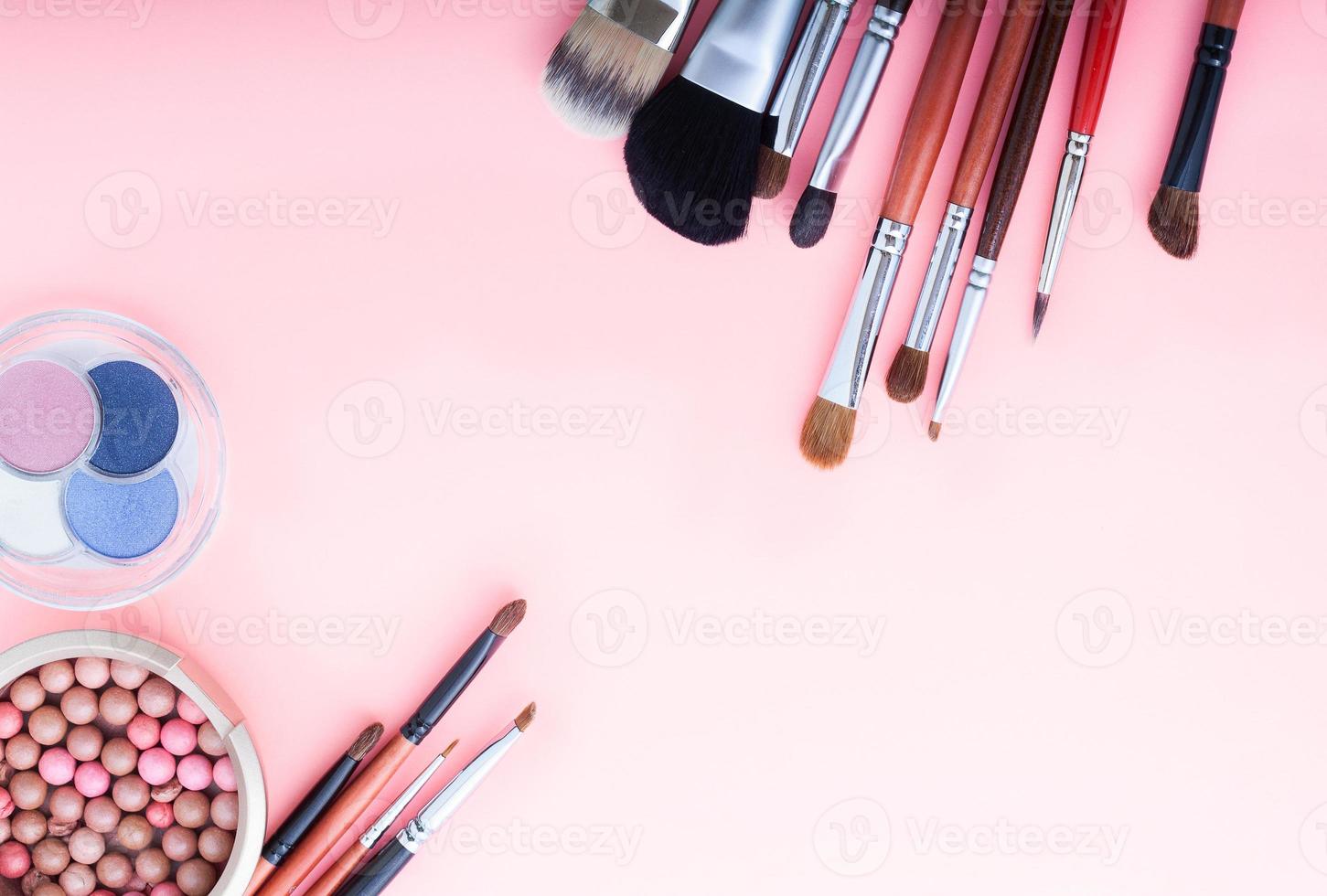 Frame of cosmetic accessories on pink background with copy space. Top view photo