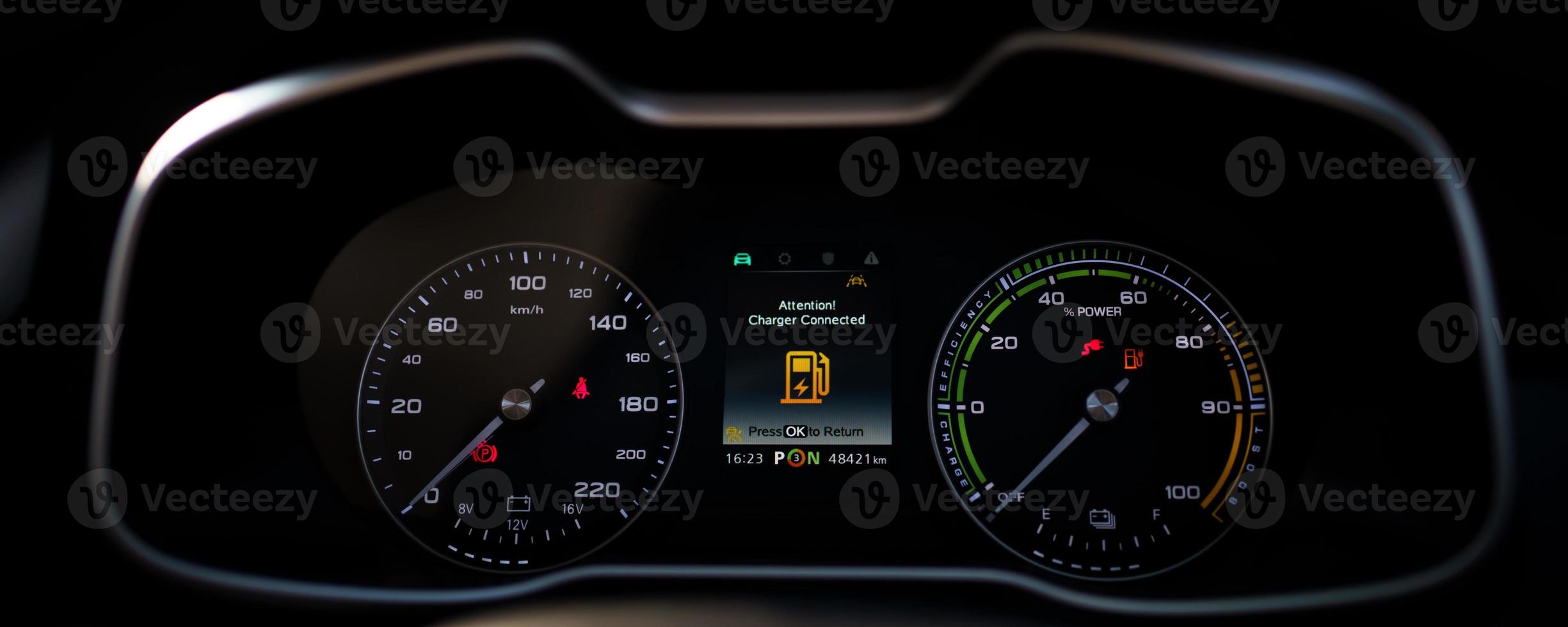 Digital modern dashboard in a electric vehicle - EV while charging at the charging station, battery electric vehicle or BEV. Dashboard in the vehicle showing charging status. photo