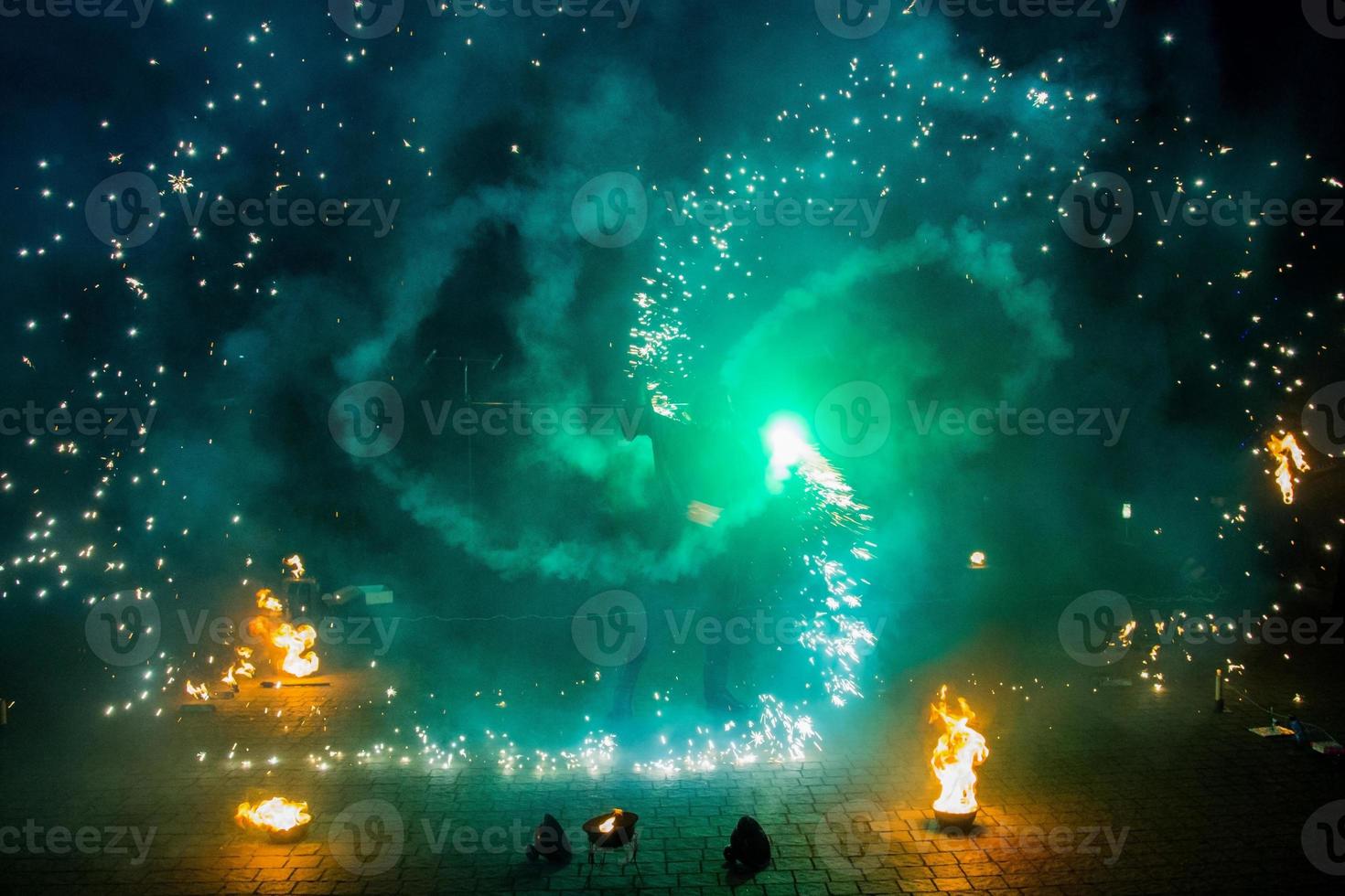 Fire show of smoke, steam and bright light effects. Dance with fire, amateur performance photo