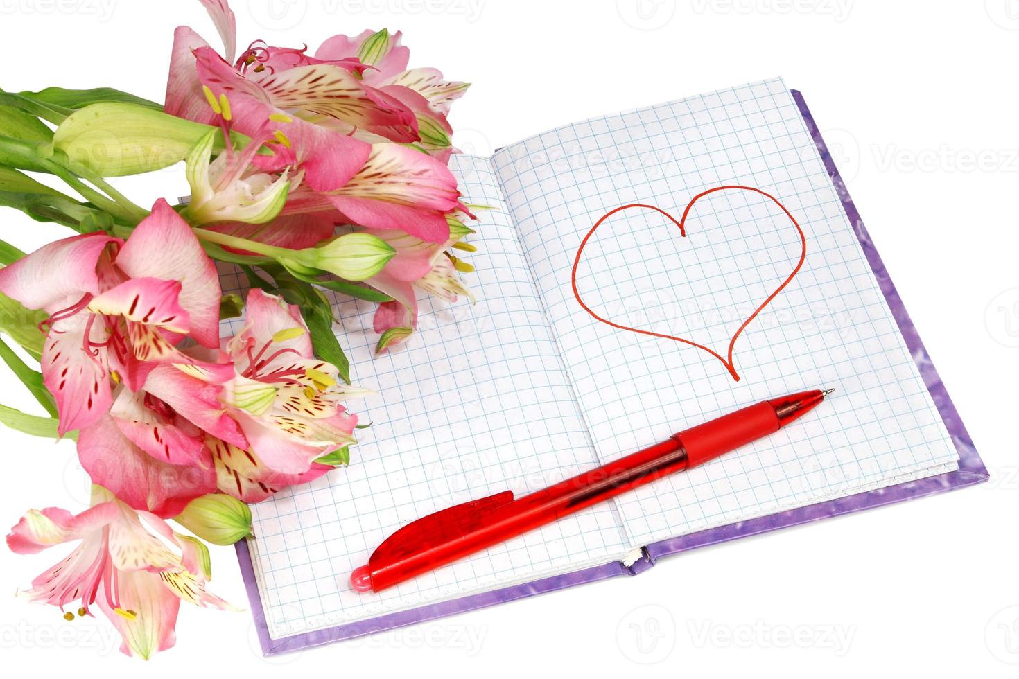 notebook with a pen by flowers and heart photo