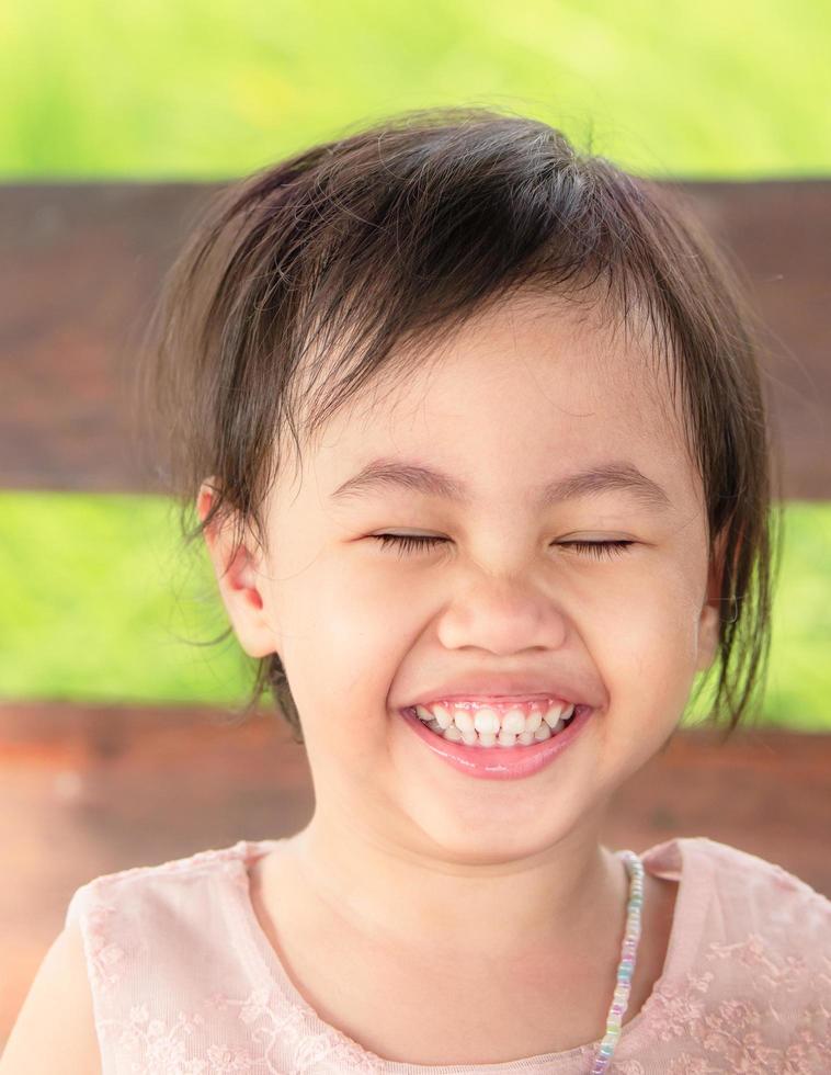 retrato de una niña asiática de risa feliz de cuatro años, un niño pequeño en edad preescolar. foto