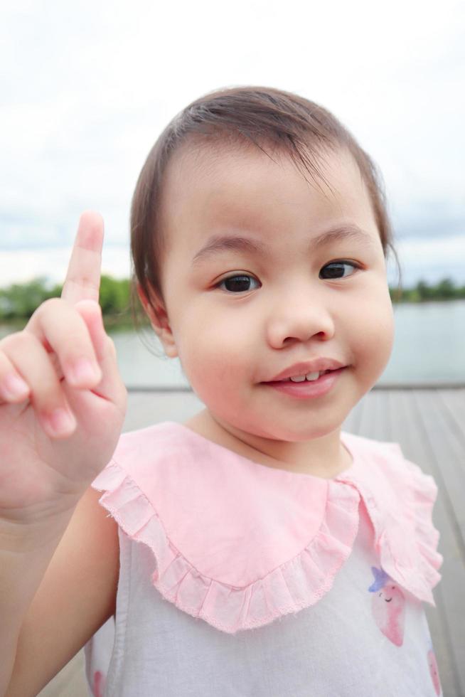 Portrait of happy charming 4 years old cute baby Asian girl, little preschooler child with toothy beaming smile looking to the camera. photo