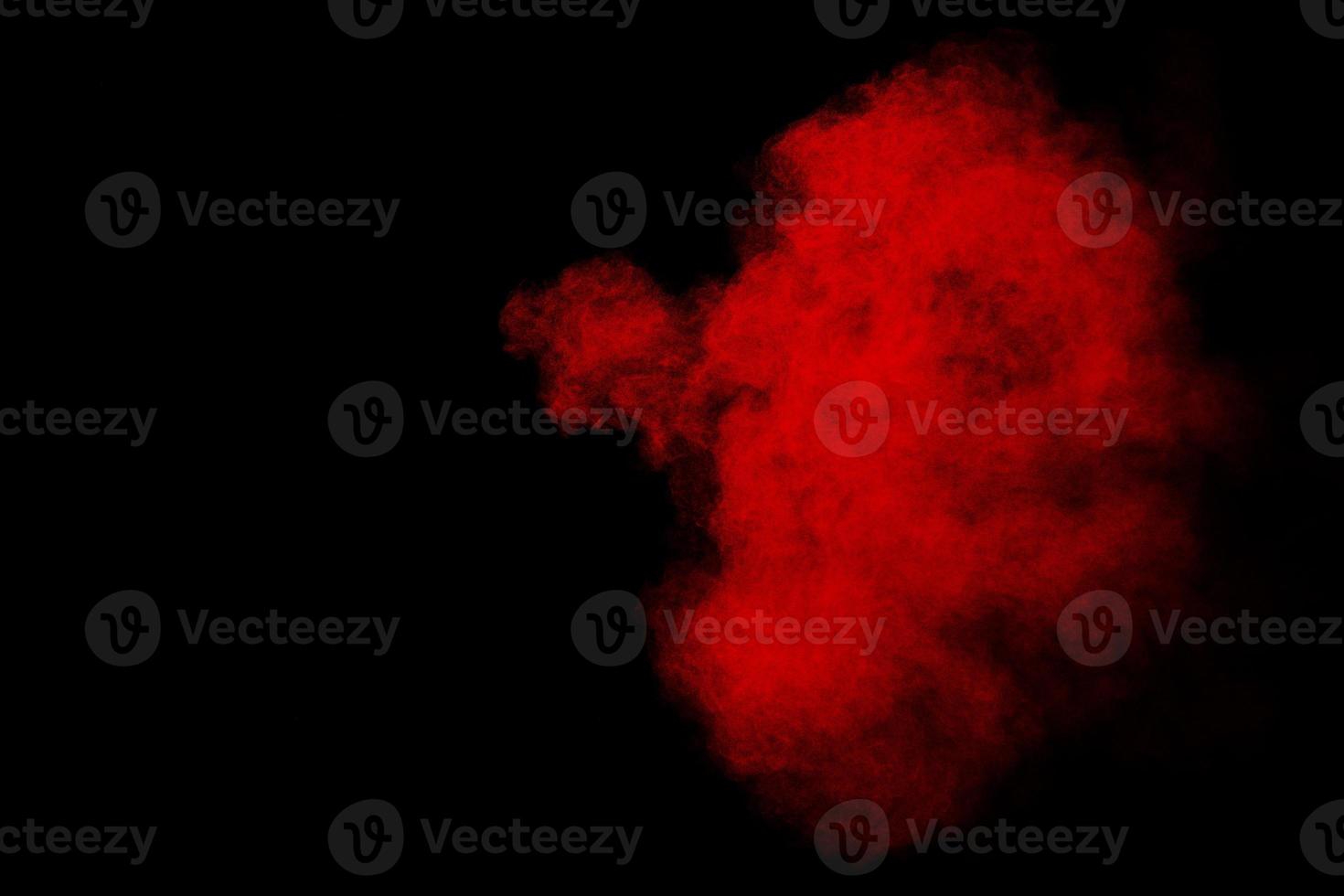 Red powder explosion cloud on black background. photo