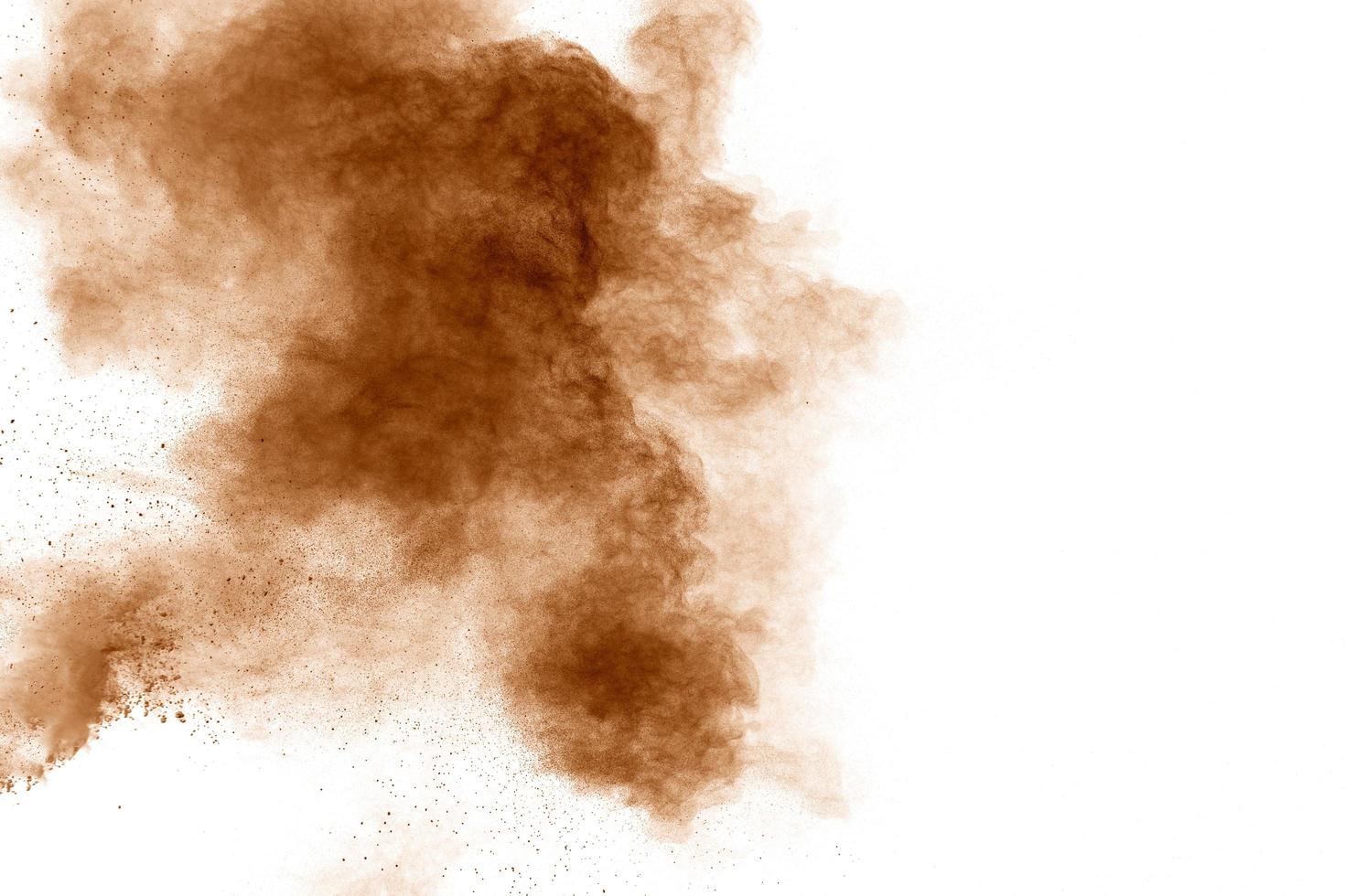 Brown dust explosion cloud.Brown particles splatter on white background. photo