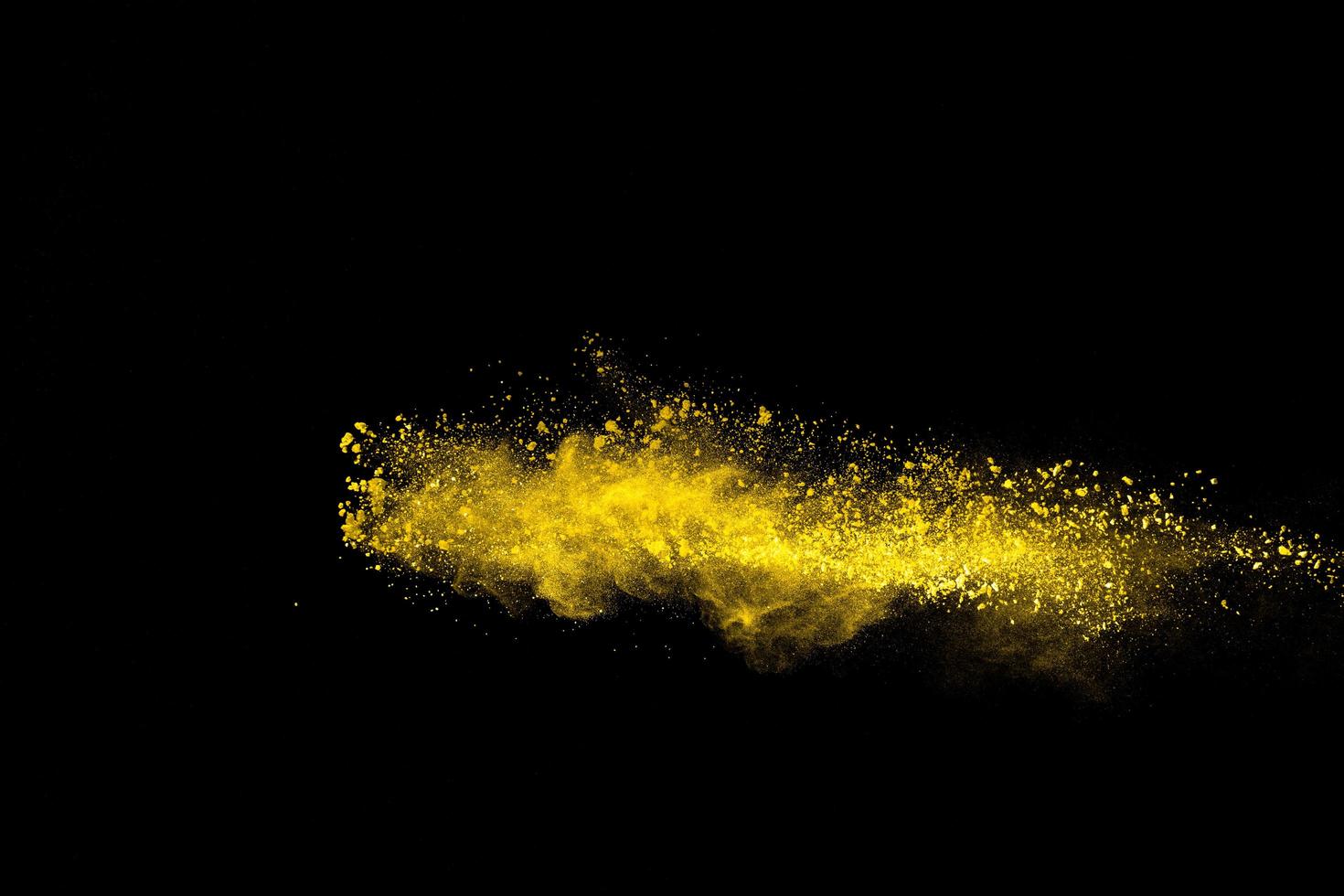 Yellow color powder explosion on black background. photo